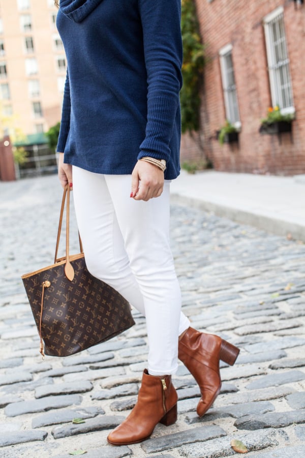 white jeans tan boots navy sweater louis vuitton
