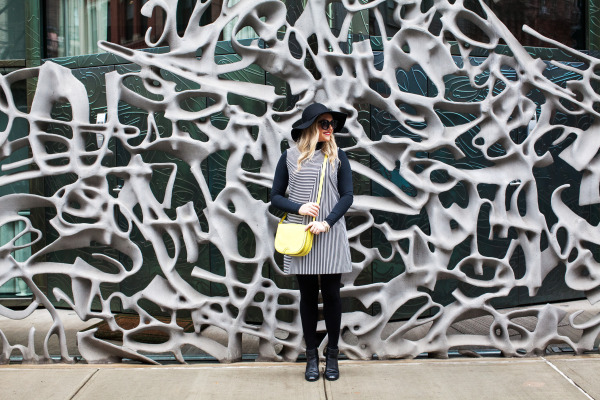 black hat, black and white striped dress, black ankle booties, yellow crossbody bag