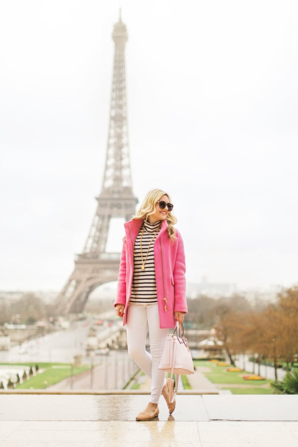 pink coat in front of the eiffel tower