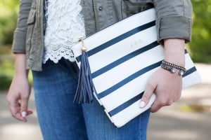Bows & Sequins wearing a monogrammed striped clutch with a tassel in NYC.