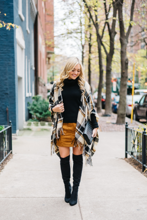 Jessica Sturdy styling a plaid cape over a suede skirt and over the knee boots for a cute fall outfit in Chicago.