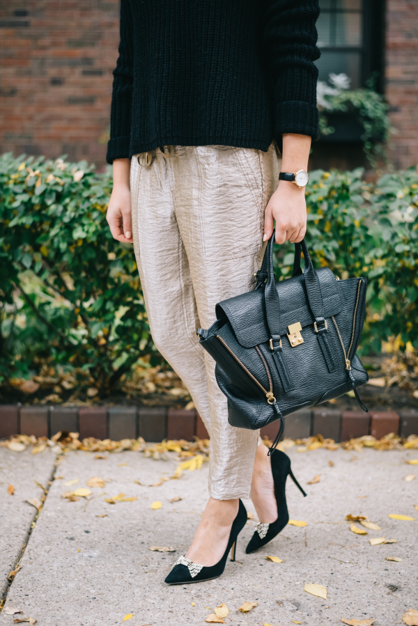 Jessica Sturdy styling a black sweater with gold pants, Kate Spade bow pumps, and a medium black Phillip Lim Pashli Tote
