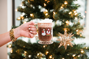 Mug of Hot Cocoa with Whipped Cream in front of a Christmas Tree