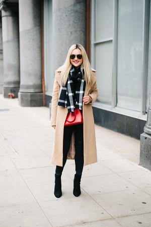 Bows & Sequins styling an outfit for a winter basketball game: long camel coat, black sweater, black jeans and booties, windowpane scarf, and a pop of red (or your teams colors!)