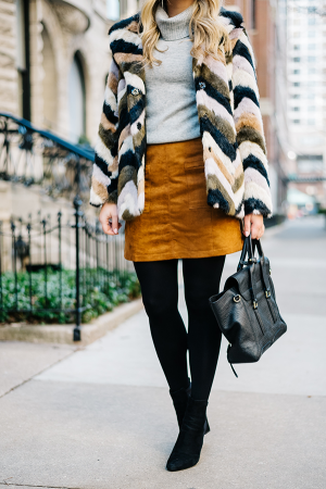 Bows & Sequins styling a faux fur jacket for winter: grey turtleneck, suede skirt, black tights, booties