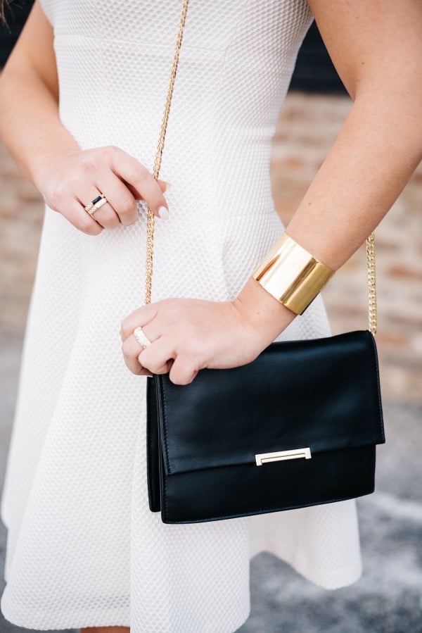 black leather gold chain clutch crossbody bag, white dress, gold cuff