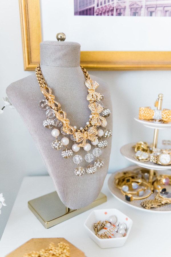 Blogger Jessica Sturdy of Bows & Sequins shares her Chicago Parisian-chic bedroom design. Necklace bust display with gold and pearl jewelry.