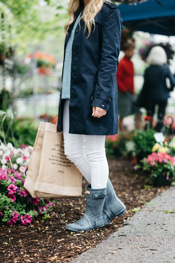 Bows & Sequins at Green City Market in Lincoln Park wearing a navy Tommy Hilfiger trench coat, a gingham top, white jeans, an Apolis farmers market straw tote, and blue Hunter rain boots.