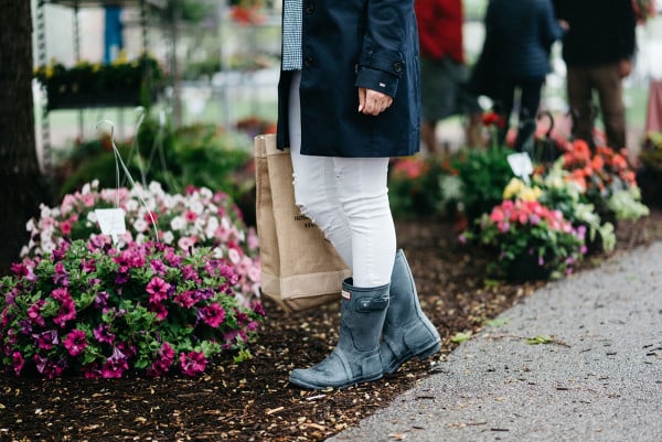 Bows & Sequins at Green City Market in Lincoln Park wearing a navy Tommy Hilfiger trench coat, a gingham top, white jeans, an Apolis farmers market straw tote, and blue Hunter rain boots.