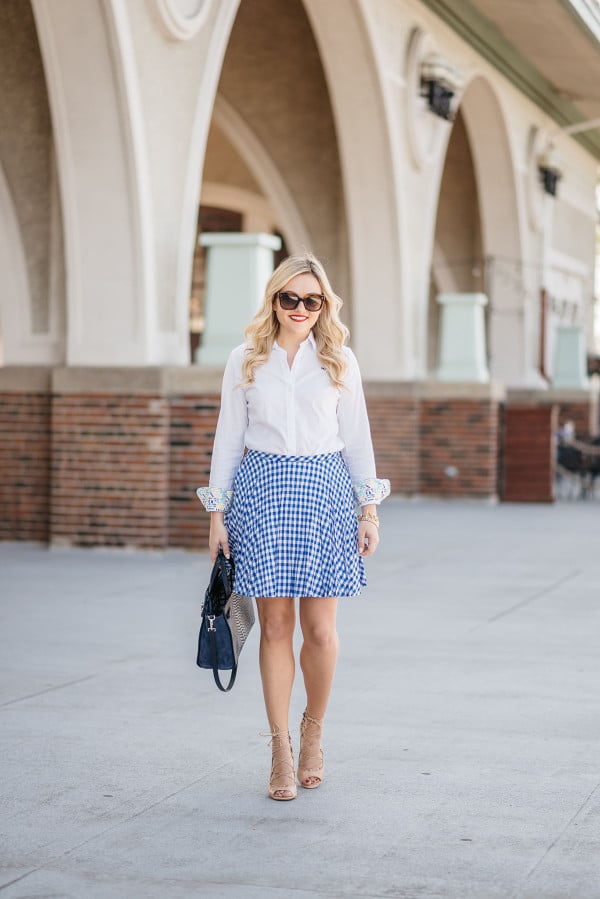 Bows & Sequins wearing a work outfit: White Oxford Shirt, Blue Gingham Skirt, Nude Lace-Up Heels, and a Navy Blue Kate Spade Bag.