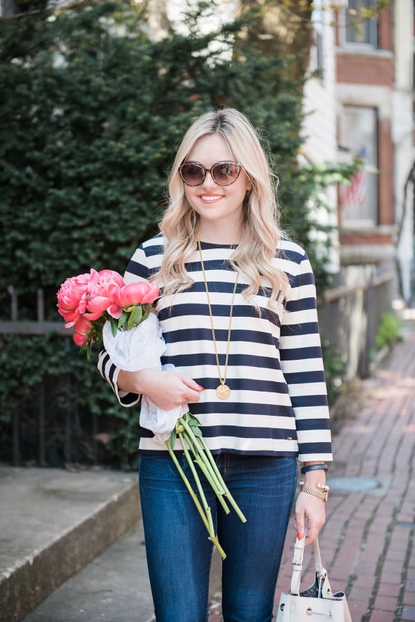Bows & Sequins wearing a Tommy Hilfiger striped shirt with a bouquet of pink peonies in Old Town Chicago. 