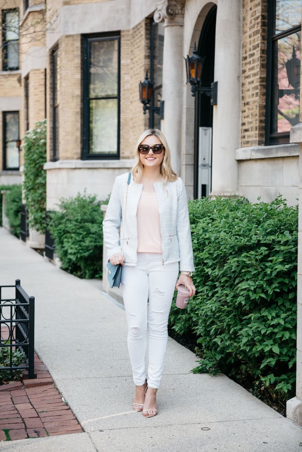 Fashion blogger, Jessica Sturdy of Bows & Sequins, wearing a light blue tweed jacket, a coral tee, white ripped jeans, and nude ankle-strap sandals.