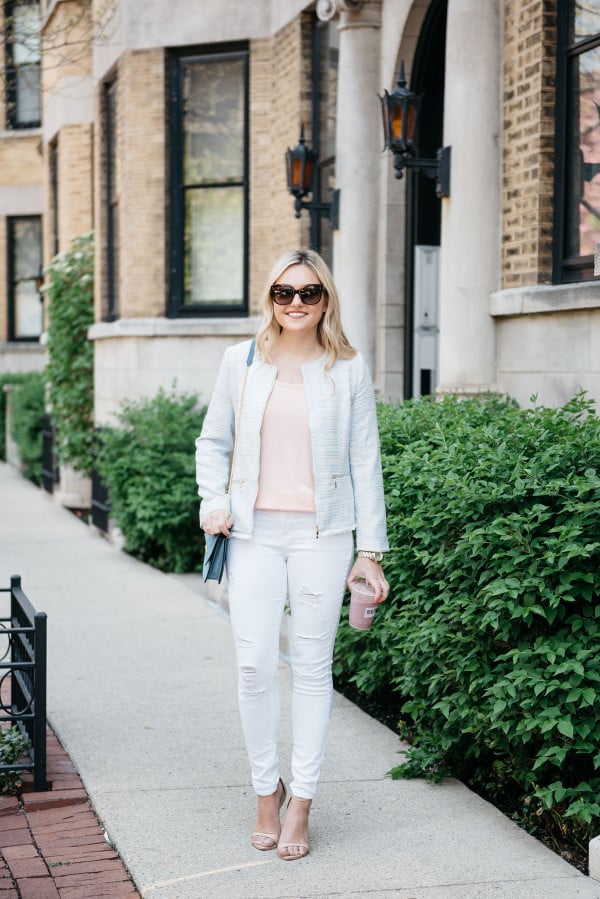 Fashion blogger, Jessica Sturdy of Bows & Sequins, wearing a light blue tweed jacket, a coral tee, white ripped jeans, and nude ankle-strap sandals.