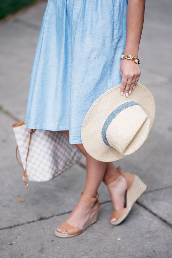 Bows & Sequins wearing a Banana Republic ruffled v-neck dress, Club Monaco straw hat, Louis Vuitton Damier Azur Neverfull Tote, Express cat-eye sunglasses, and Vince Camuto leather espadrille wedges to the Veuve Clicquot Polo Classic in New York.