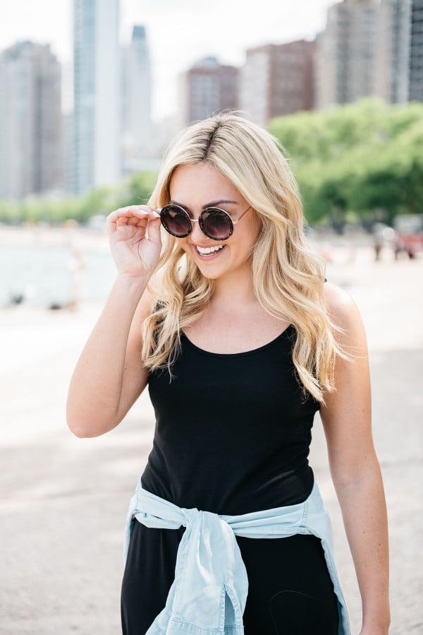 Bows & Sequins at North Avenue Beach in Chicago wearing a black maxi dress and chambray shirt with a straw hat and round glitter sunglasses.