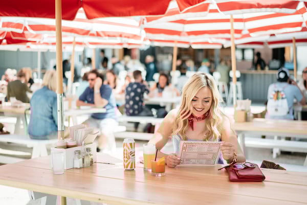 Bows & Sequins visits Parson's Chicken and Fish in Chicago. Jessica is wearing a white and blue gingham top with all red accessories: a red bandana tied around her neck, a red clutch, red sunglasses, and red lipstick. A fun Americana-inspired outfit that's perfect for Fourth of July festivities!