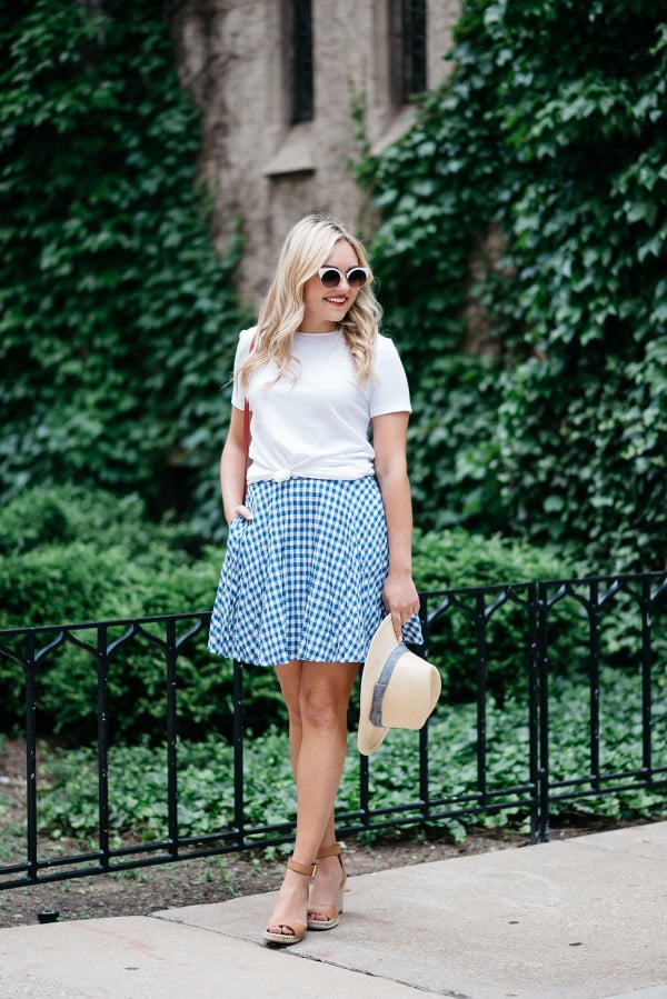 Bows & Sequins wearing an Americana Red, White, and Blue outfit for July 4th weekend! A white Old Navy knotted tee, a blue and white J.Crew gingham skirt, a Club Monaco straw hat, a red Ralph Lauren handbag, and Vince Camuto leather espadrille wedges.