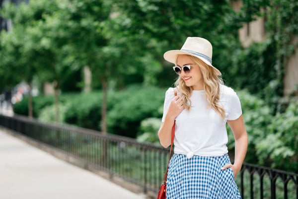 Bows & Sequins wearing an Americana Red, White, and Blue outfit for July 4th weekend! A white Old Navy knotted tee, a blue and white J.Crew gingham skirt, a Club Monaco straw hat, a red Ralph Lauren handbag, and Vince Camuto leather espadrille wedges.