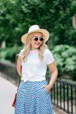Bows & Sequins wearing an Americana Red, White, and Blue outfit for July 4th weekend! A white Old Navy knotted tee, a blue and white J.Crew gingham skirt, a Club Monaco straw hat, a red Ralph Lauren handbag, and Vince Camuto leather espadrille wedges.