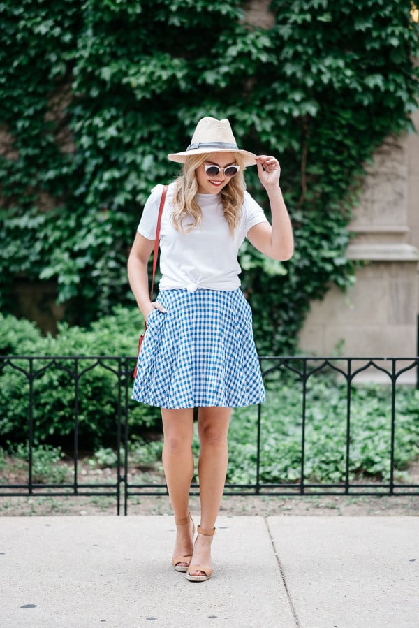 Bows & Sequins wearing an Americana Red, White, and Blue outfit for July 4th weekend! A white Old Navy knotted tee, a blue and white J.Crew gingham skirt, a Club Monaco straw hat, a red Ralph Lauren handbag, and Vince Camuto leather espadrille wedges.