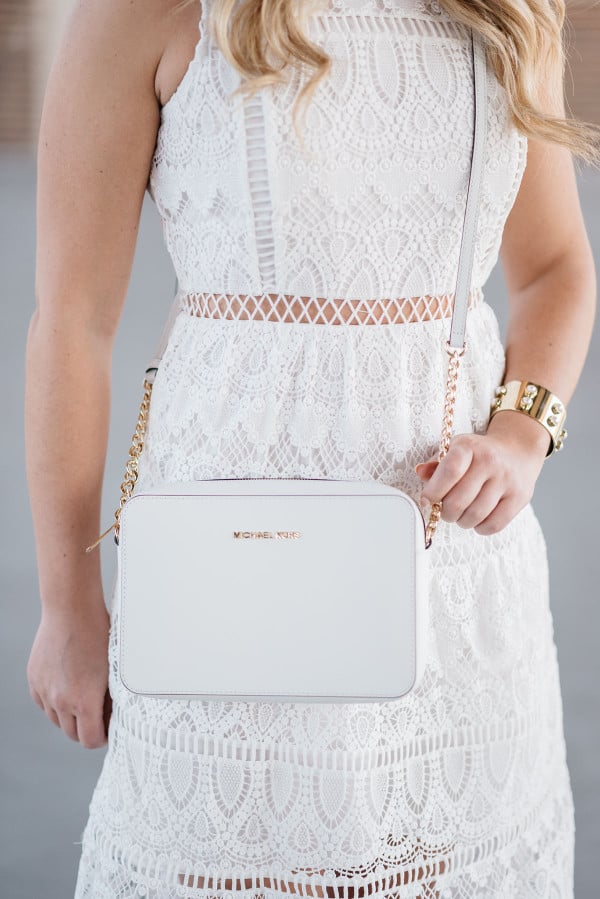 Bows & Sequins wearing a white lace dress and a Michael Kors white crossbody bag in Chicago.
