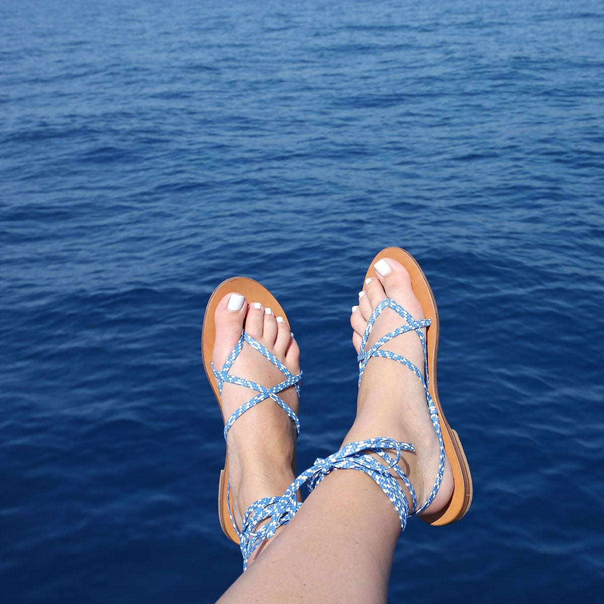 Bows & Sequins sailing on the Mediterranean Sea from Positano to Capri on the Amalfi Coast. Wearing a pair of lace-up M.Gemi sandals!