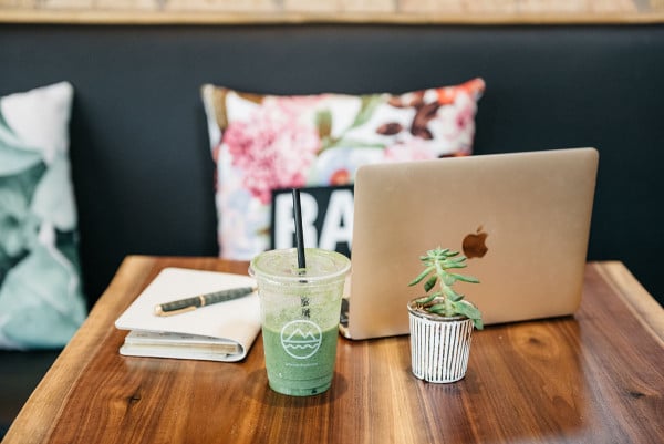 Left Coast Food in Chicago is one of @bowsandsequins' favorite spots for healthy eating and working remotely. Jessica's workday essentials are pictured here: a GigiNY leather journal and a gold Apple Macbook.