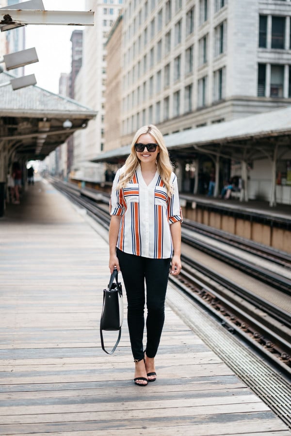 Chicago Blogger Jessica Sturdy of Bows & Sequins styling a striped button-front shirt, black skinny jeans, ankle-strap heels, and a color-blocked black and white tote for a work-appropriate outfit on the Chicago El Train platform in the Loop downtown.