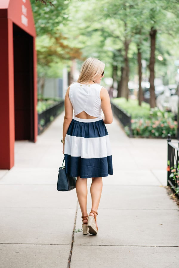 Blogger @bowsandsequins wearing a navy and white striped Elizabeth McKay dress with a cutout back styled with leather espadrille wedges, Celine sunglasses, a navy blue Kate Spade bag, and a tortoise link necklace.