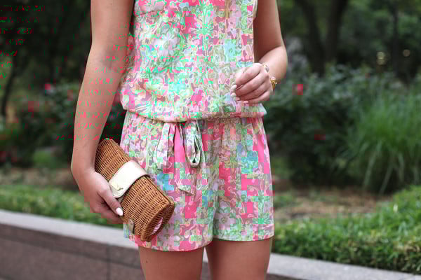 Bows & Sequins wearing a printed Lilly Pulitzer romper with a wicker clutch.