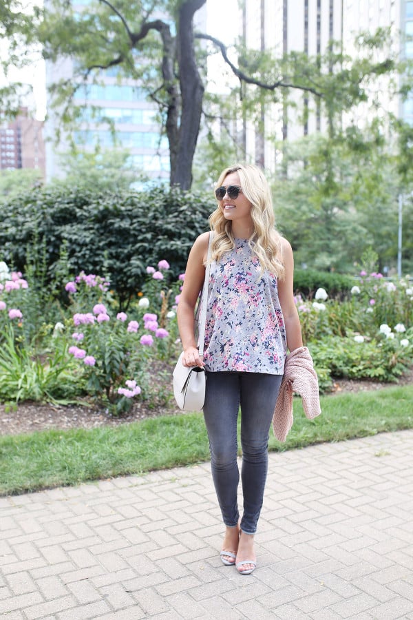 Fashion blogger Bows & Sequins wearing grey jeans, a floral paisley-printed top from Old Navy, a Kate Spade crossbody bag, and Dior sunglasses.