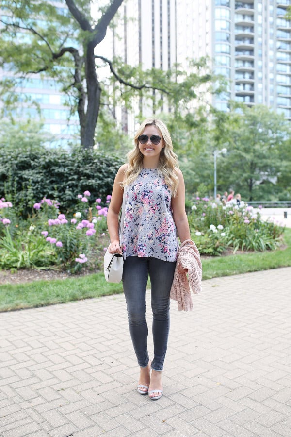 Fashion blogger Bows & Sequins wearing grey jeans, a floral paisley-printed top from Old Navy, a Kate Spade crossbody bag, and Dior sunglasses.