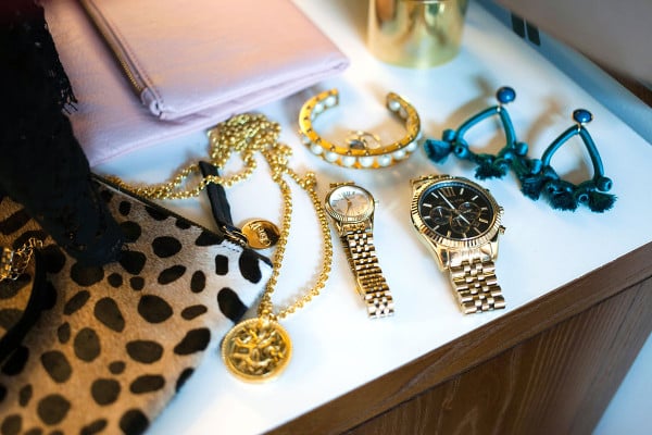 Style blogger Bows & Sequins displays a purse, bracelet, necklace, watch, earrings, and more while preparing for a special occasion on New York.