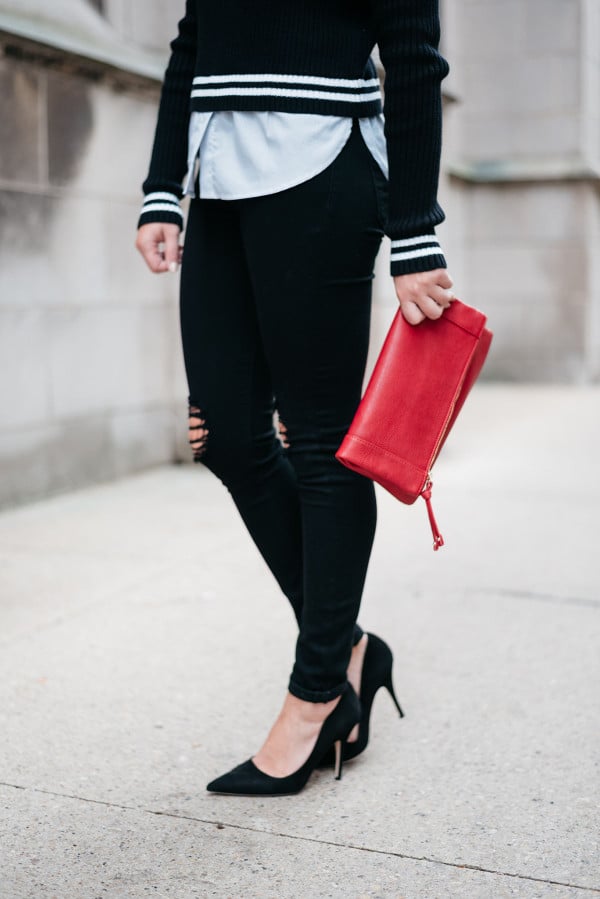 Jessica Sturdy of Bows & Sequins wearing black ripped jeans, red clutch purse, and black heels.