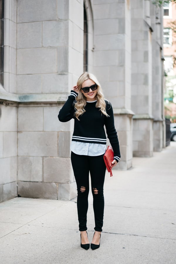 Style blogger Jessica Sturdy of Bows & Sequins wearing a black and white stripe sweater, black jeans, sunglasses, and a red clutch purse.