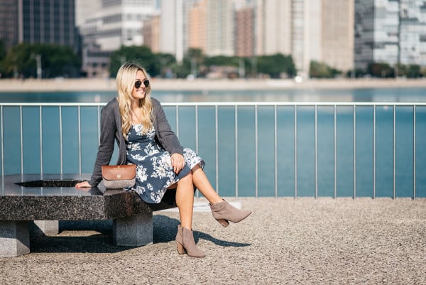 Bows & Sequins, fashion blogger, wearing a navy dress, grey long sweater, clutch purse, and aviator sunglasses in Chicago.