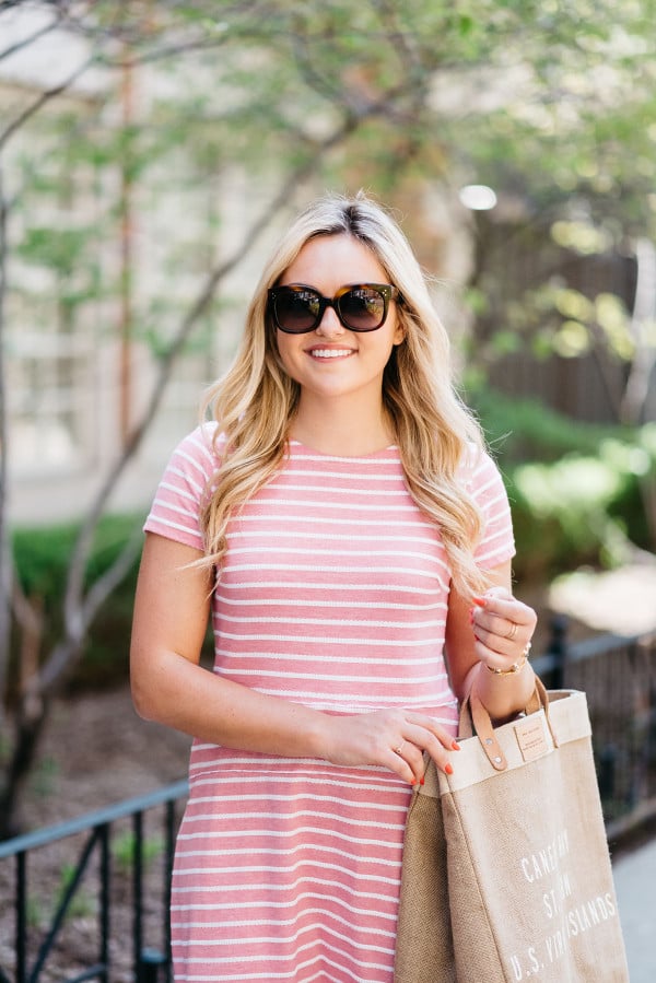 Fashion blogger Bows & Sequins wearing a Sail to Sable pink and white striped dress, Celine sunglasses, and a tan tote.
