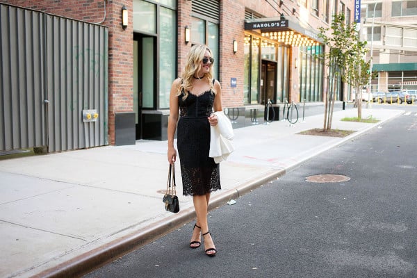 Fashion blogger Bows & Sequins wearing a little black dress, Gucci purse, strap sandals, and sunglasses in New York City.