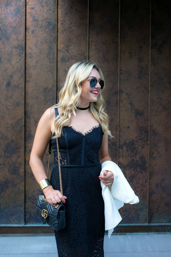 Fashion blogger Bows & Sequins wearing a black dress, black choker necklace, sunglasses, and crossbody purse in NYC.