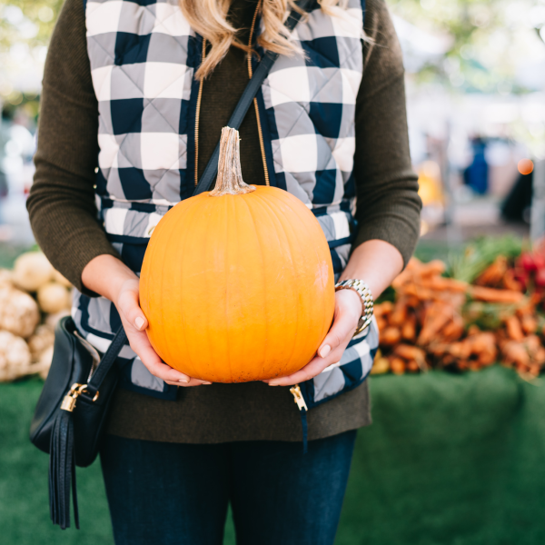 Blogger Bows & Sequins wearing a cute gingham vest and olive green sweater at a pumpkin patch!