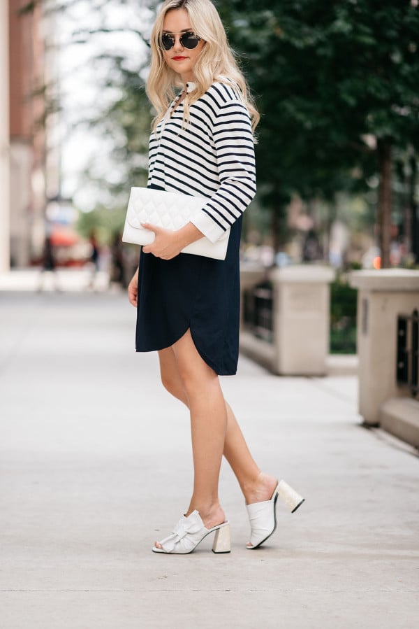 Jessica Sturdy of Bows & Sequins, a fashion-focused lifestyle blog, wearing a striped shirtdress, white clutch purse, Topshop bow shoes, and sunglasses in Chicago's Gold Coast.