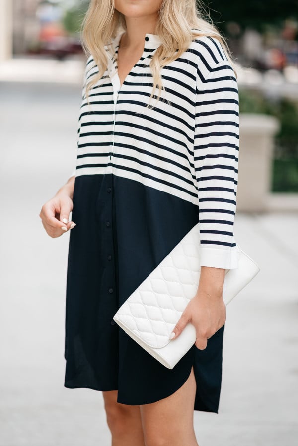 Jessica Sturdy of Bows & Sequins, a fashion-focused lifestyle blog, styles a Vera Bradley white clutch purse with a striped t-shirt dress.