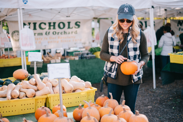 Blogger Bows & Sequins wearing a cute gingham vest and olive green sweater at a pumpkin patch!