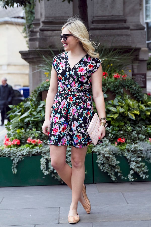 Fashion blogger Bows & Sequins wearing a navy floral Yumi Kim Wrap Dress and Vera Bradley leather clutch in London.