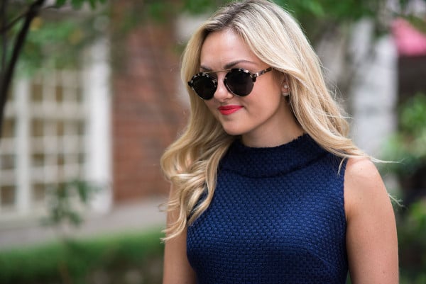 Style blogger Bows & Sequins wearing a navy blue dress with sunglasses in Chicago.