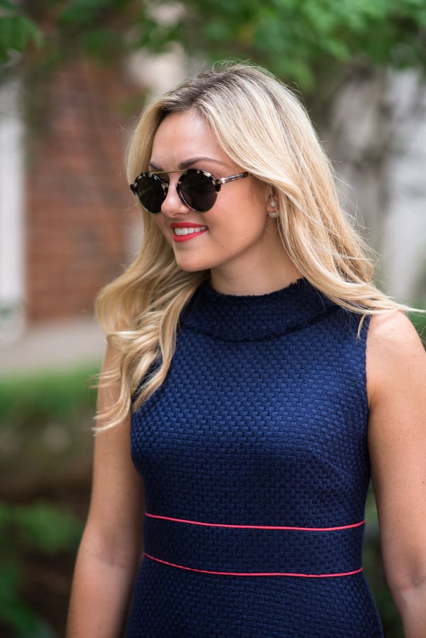 Style blogger Bows & Sequins wearing a navy blue dress with sunglasses in Chicago.