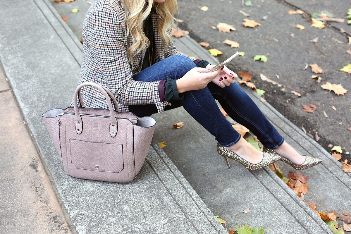 Fashion blogger Bows & Sequins styling a plaid blazer, skinny jeans, and glitter pumps for the office.
