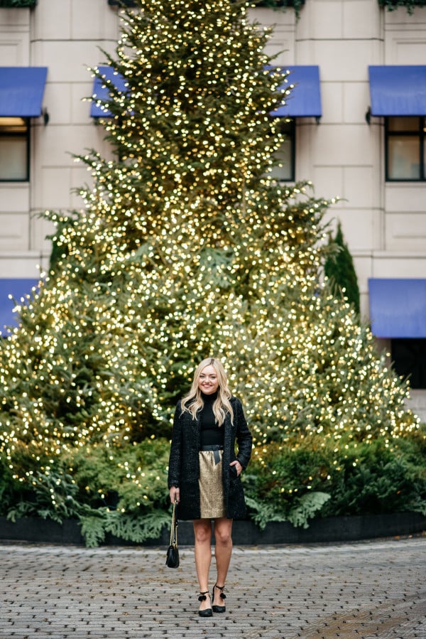 Bows & Sequins styling a black and gold holiday outfit: Sail to Sable sparkly tweed jacket, a black turtleneck, a gold tweed skirt with a bow belt, a Gucci Marmont bag, and Kate Spade glitter pom-pom heels! Photo taken in front of the Christmas Tree at the Waldorf Astoria in Chicago's Gold Coast.