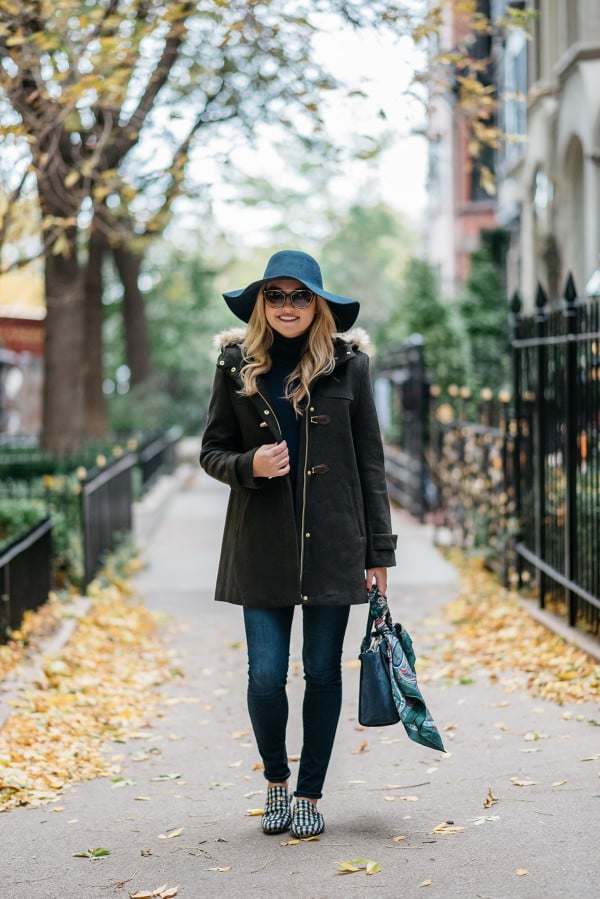 Bows & Sequins styling a fall outfit: floppy hat, dark green toggle coat, Rag & Bone skinny jeans, Gucci loafers, Tom Ford sunglasses, and a Kate Spade bag.