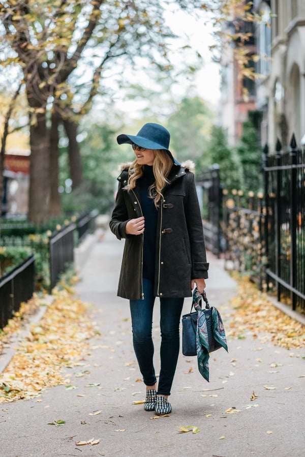 Bows & Sequins styling a fall outfit: floppy hat, dark green toggle coat, Rag & Bone skinny jeans, Gucci loafers, Tom Ford sunglasses, and a Kate Spade bag.